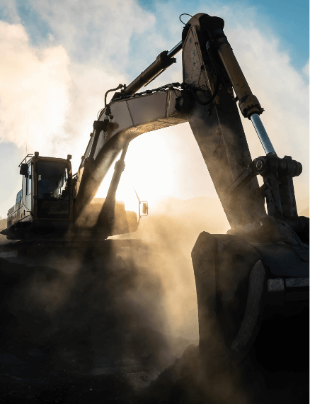 excavator in a sunset throwing up dust